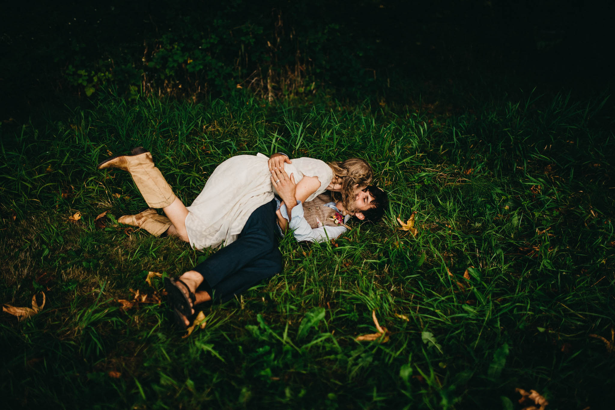 bride and groom laying in grass